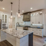 Granite countertops and two pendant lights above island
