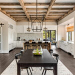 Stunning kitchen and dining room in new luxury home. Wood beams and elegant pendant lights accent this beautiful open-plan dining room and kitchen